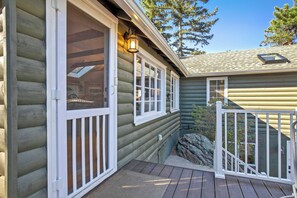 A log cabin with a porch, a window with a view, and a lantern. - Oakwood Lodge! Secluded Forest Retreat w/ Hot Tub (Green Mountain Falls)