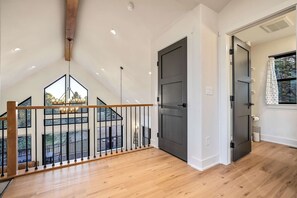 A spacious room with a high ceiling, a wooden railing, and a view of an outdoor area. - Conestoga Creek! NEW Secluded Cabin w/Deck & Views (Florissant)
