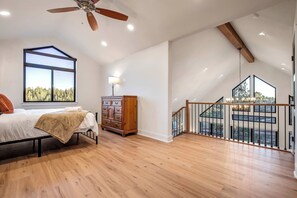 A bedroom with a large window, a ceiling fan, and a wooden dresser. - Conestoga Creek! NEW Secluded Cabin w/Deck & Views (Florissant)