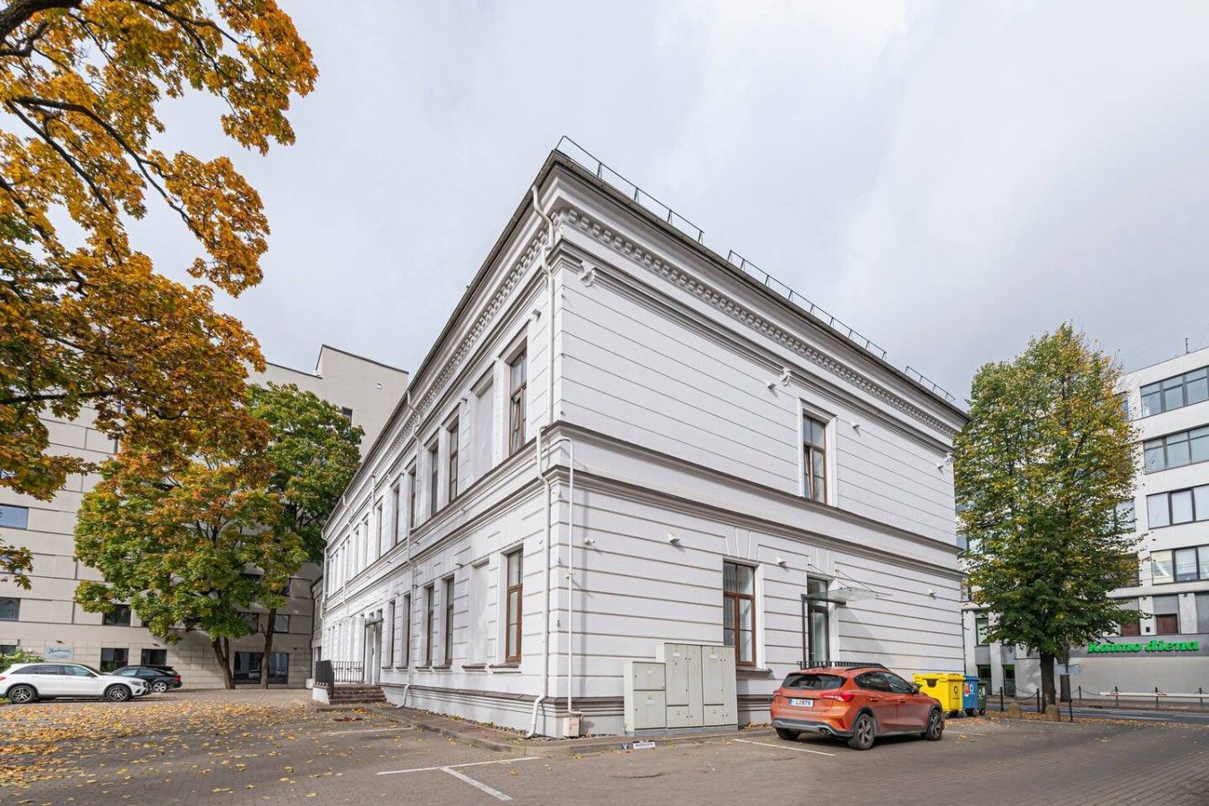 Un bâtiment blanc de style architectural classique, caractérisé par une façade symétrique, de grandes fenêtres et une entrée centrale.