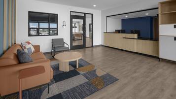 A modern living room with a sofa, a coffee table, and a patterned rug.