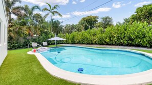 A swimming pool with a surrounding grassy area, a lounge chair, and a small umbrella. - Entire 4 beds house w/ pool 15mint HardRockCasino, Beach, FLL Air - Cruise ports (Hollywood)