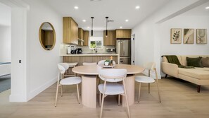 A modern kitchen with a dining area, wooden cabinets, and a round table with chairs. - Entire 4 beds house w/ pool 15mint HardRockCasino, Beach, FLL Air - Cruise ports (Hollywood)