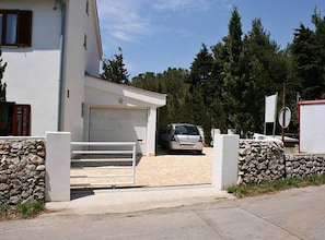 Ein modernes, zweistöckiges Haus mit Garage, Steinmauer und gepflasterter Auffahrt.