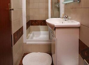Ein kleines Badezimmer mit Toilette, Waschbecken und Dusche.