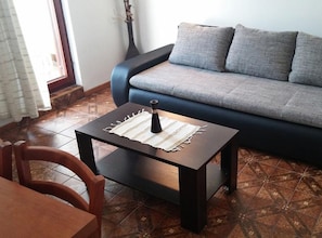 Ein Wohnzimmer mit einer Couch, einem Couchtisch und einem Sessel.