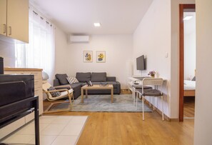 A modern living room with a sofa, a coffee table, a TV, and a dining area with chairs. - Zabljak Hills City Center-only 400m walking distance from the center (Žabljak)