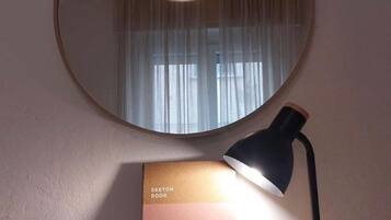 Un bureau avec une lampe, un carnet de croquis et une plante en pot.