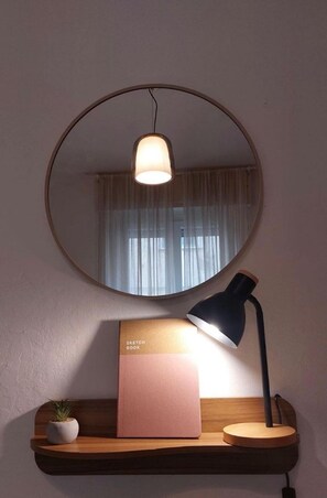 Un bureau avec une lampe, un carnet de croquis et une plante en pot.