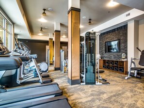 A gym with treadmills, a weight machine, and a TV on the wall. - AEA -  E Riverside Dr. TX  (Austin)