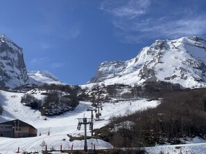 A snow-covered mountain landscape with a ski lift and a building. - Studio in resort with elevator - Slope views (Gourette)