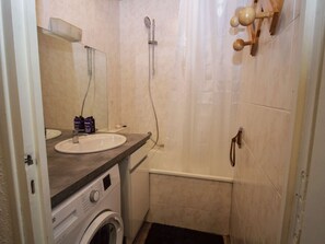 A compact bathroom with a sink, mirror, shower, and a washing machine. - Ideal studio in the center - 3 guests (Valloire)