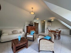 A modern loft-style living space with a dining area, kitchenette, and a staircase. - Quiet house with WIFI 600m from the sea (Trégastel)