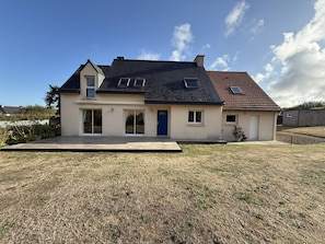 A two-story house with a flat roof, large windows, and a front porch. - Quiet house with WIFI 600m from the sea (Trégastel)