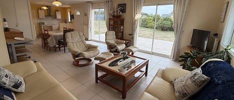 A living room with a sofa set, a coffee table, and a dining area with chairs and a table.