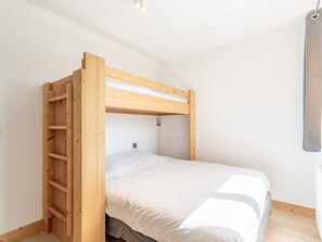 A bunk bed with a wooden ladder and a single bed below. - Spacious apartment, mountain view - 5 guests (Les Arcs 1800)