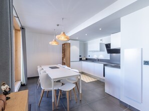 A modern kitchen with white cabinets, a central island, and pendant lighting. - Spacious and quiet duplex - 12 guests (Les Arcs 1800)