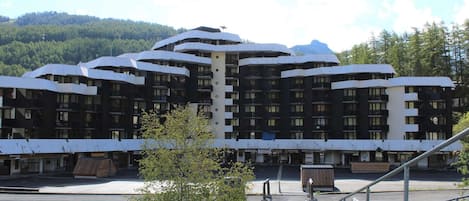 Un hotel moderno con un diseño arquitectónico único, que cuenta con varios balcones y un patio central.