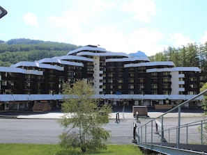 Ett modernt hotell med en unik arkitektonisk design, med flera balkonger och en central innergård.