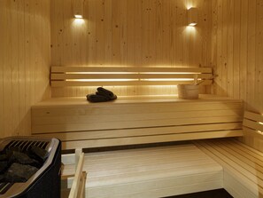 A sauna with wooden benches, a towel rack, and a bucket. - Luxurious 5-Star Chalet in Morzine - Sleeps 12, Jacuzzi, Sauna, Near Ski Lift (Morzine)