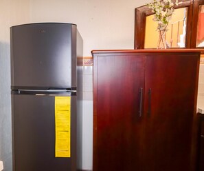 Eine Küche mit einem schwarzen Kühlschrank und Holzschränken.