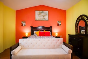 Une chambre à coucher avec un lit, deux tables de chevet, une commode et un tableau au mur.
