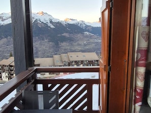 A balcony with a view of snow-capped mountains and a town below. - Appartement lumineux · Accès direct aux pistes · Balcon (Aime-la-Plagne)