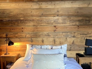 A wooden-paneled room with a bed, a lamp, and a desk with a computer. - Comfortable chalet - 12 guests (Tignes)