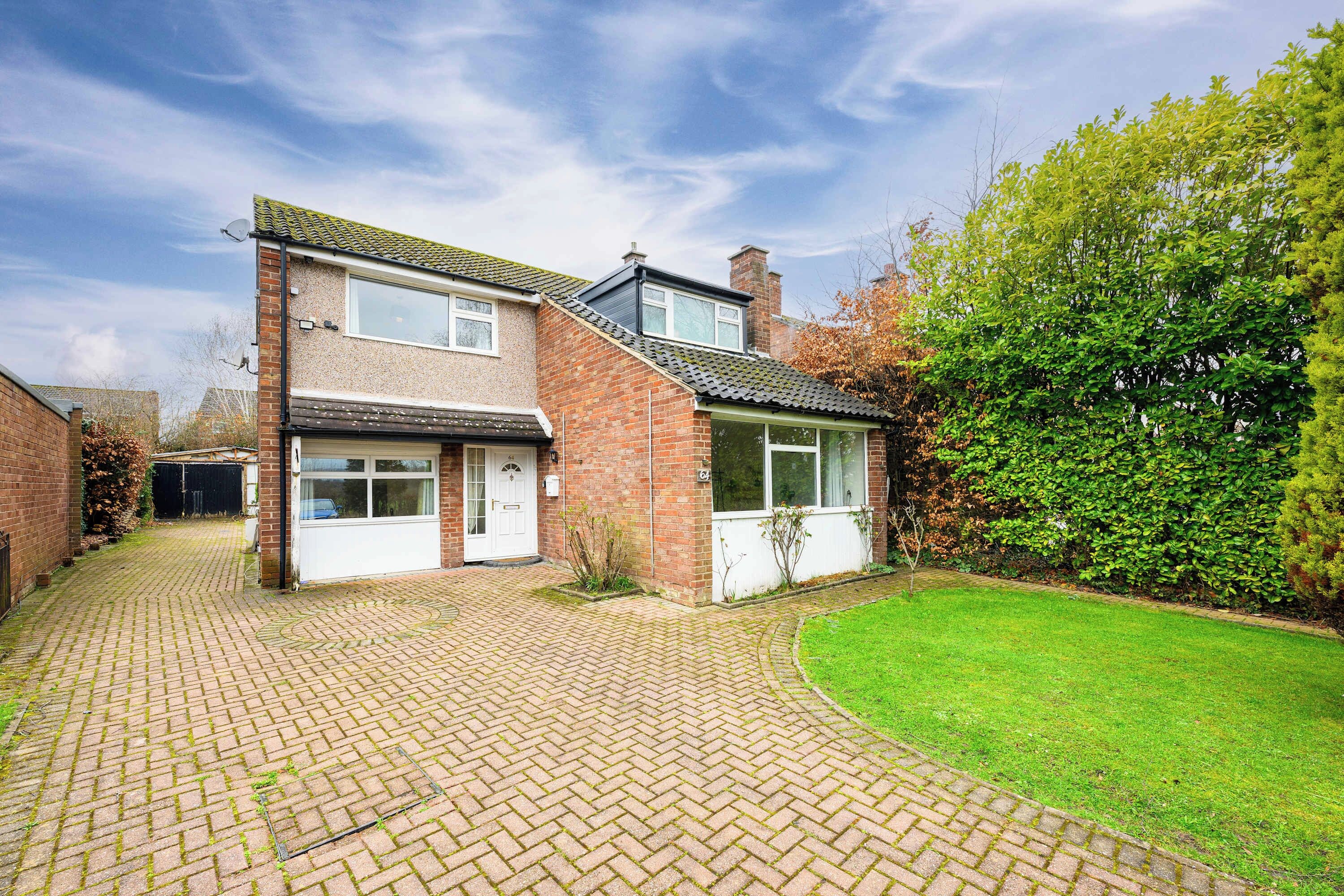 A two-story house with a brick facade, a front door, and a small front garden.
