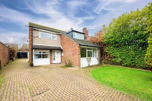 A two-story house with a brick facade, a front door, and a small front garden. - Hale Barns Home - Garden, Parking & Near Airport (Hale)