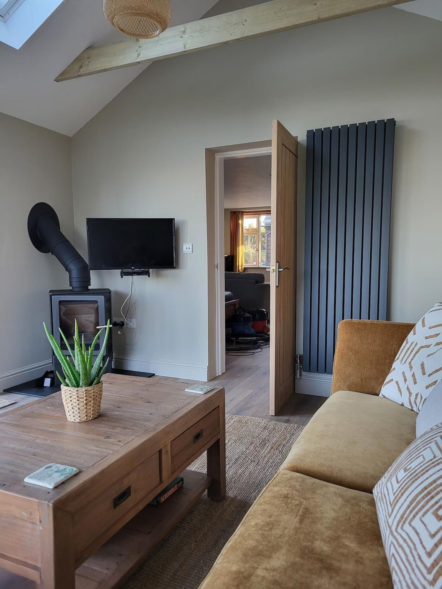 A cozy living room with a wooden coffee table, a sofa, a television, and a fireplace.