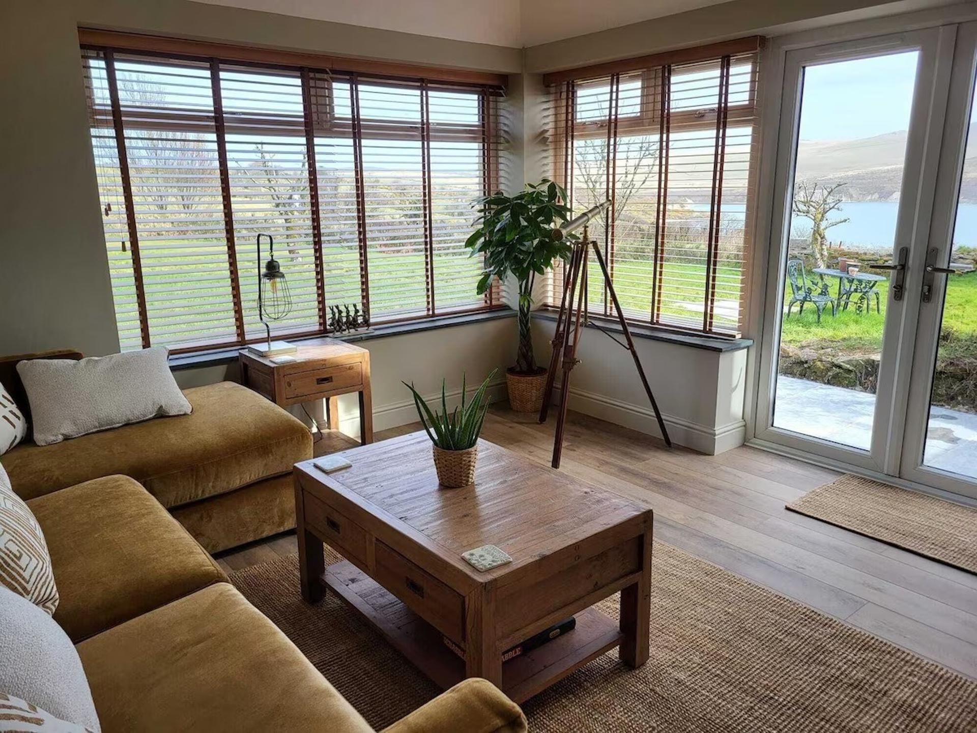 A living room with a sofa set, a coffee table, and a potted plant.