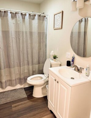 Une salle de bain avec des toilettes, un lavabo et un miroir.