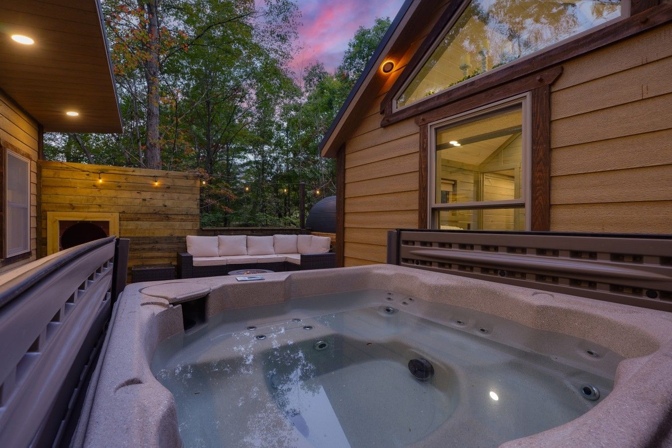 Ein Whirlpool mit einer Holzterrasse und einer gepolsterten Sitzgelegenheit.