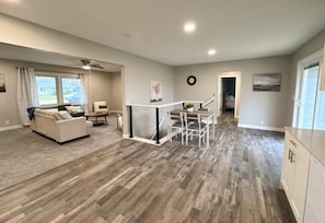 A spacious living area with a sofa, a dining table, and a kitchen area with cabinets.