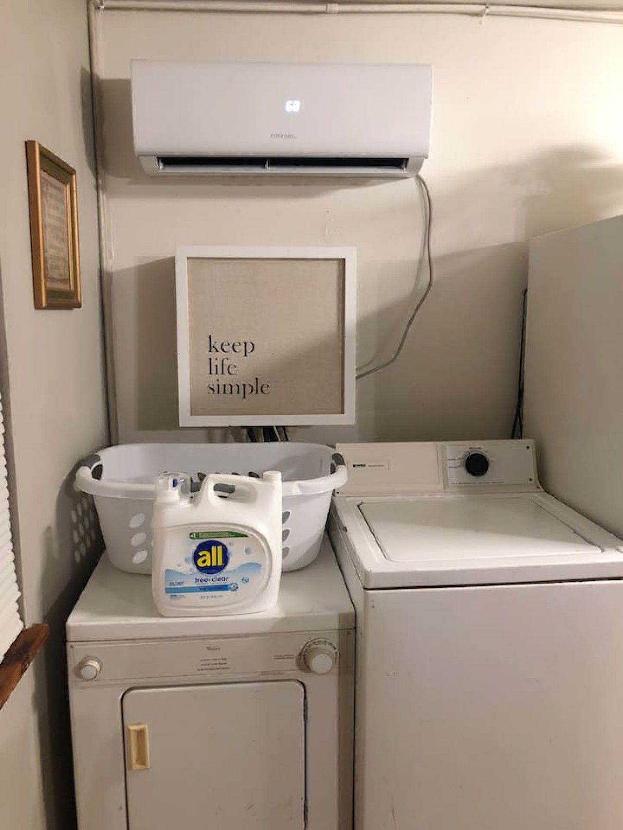 A laundry area with a washing machine, dryer, and a wall-mounted air conditioner.