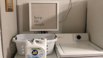 A laundry area with a washing machine, dryer, and a wall-mounted air conditioner.