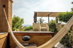 A hammock, a barbecue grill, and a view of the sea. - Oceanfront Apartment w/ Surf Views & Pool Access (Puerto Escondido)