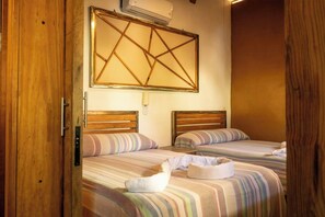 A room with two beds, wooden headboards, and a large geometric wall decoration. - Oceanview Apt w/ Pool, Zicatela Surf Proximity (Puerto Escondido)