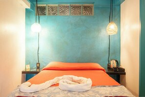 A hotel room with a bed, a nightstand, a kettle, and a towel. - Tropical Hotel w/ Pool, Steps to Zicatela Beach (Puerto escondido)