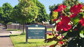A sign for Willakenzie Park with a green background and white text, indicating the park's establishment year and operating hours. - Happy Heart House | Hot Tub | Firepit (Eugene)