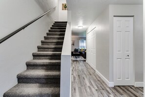 A staircase with carpeted steps leading to a landing. - Renovated Duplex Near Trails & UofO, Fenced Yard (Eugene)