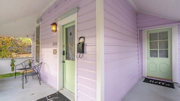 A porch with a green door, a mailbox, and a 'hello' mat.