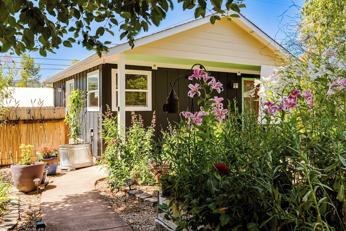 Il s’agit d’une propriété résidentielle dotée d’un porche abrité, d’un chemin menant à la maison, ainsi que de diverses plantes et fleurs en pot.