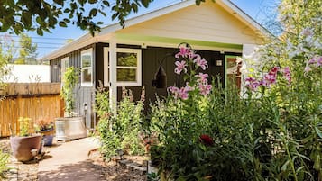 Il s’agit d’une propriété résidentielle dotée d’un porche abrité, d’un chemin menant à la maison, ainsi que de diverses plantes et fleurs en pot.