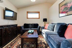 A living room with a flat-screen TV, two sofas, a coffee table, and a patterned rug. - Amazon Area Backyard ADU With Private Entrance (Eugene)