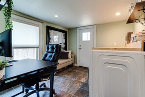 A compact living space with a dining area, a sofa, a television, and a kitchen area with a refrigerator. - Pet-Friendly House w/ Backyard & Free Parking (Springfield)