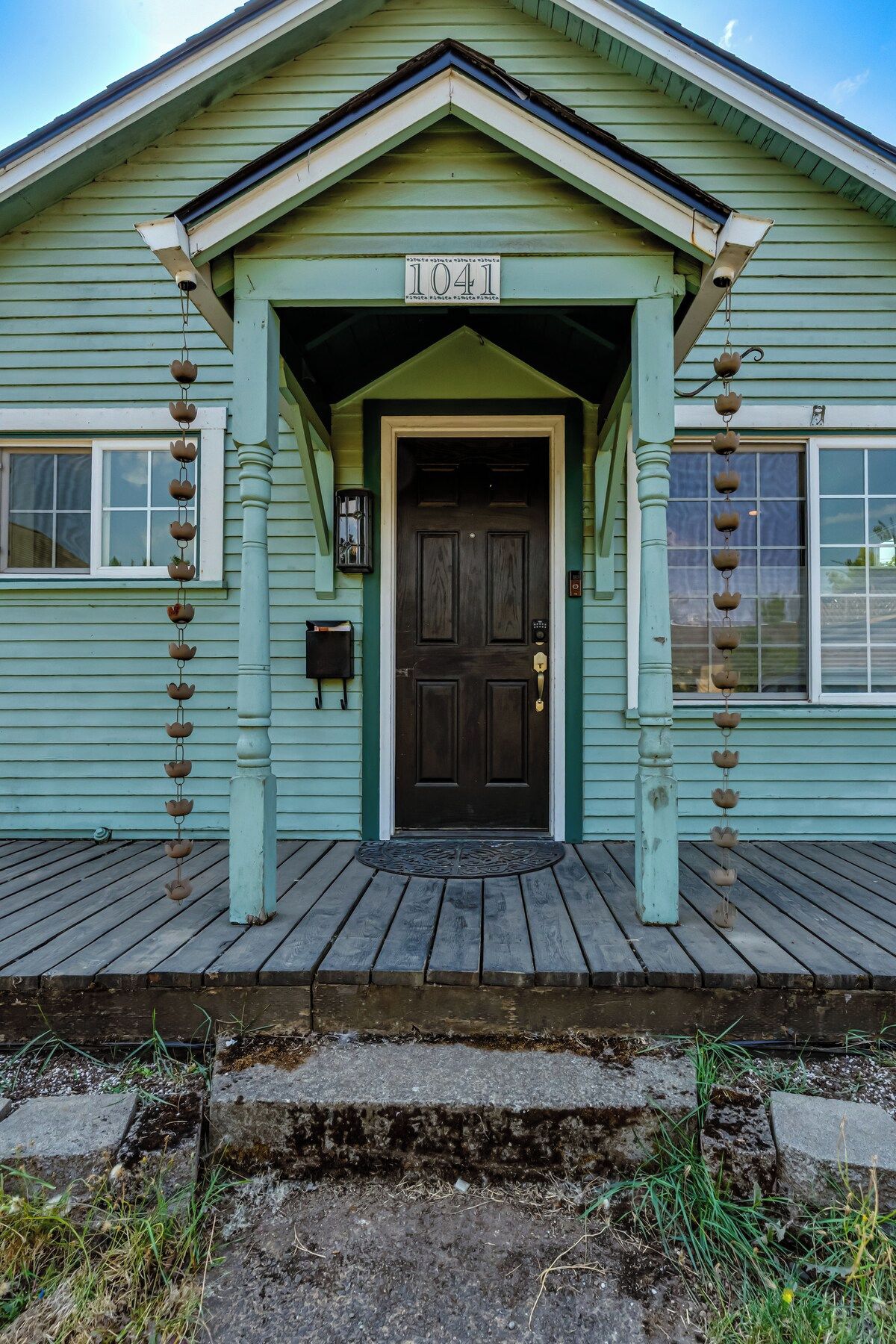 A house with a dark front door, a mailbox, and a number '1041' above the door.