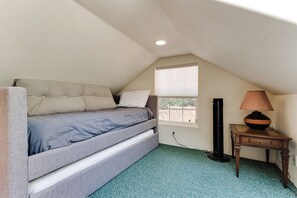 A small, cozy bedroom with a bed, a nightstand, a lamp, and a window. - Stylish House w/ Backyard & Free Parking (Eugene)