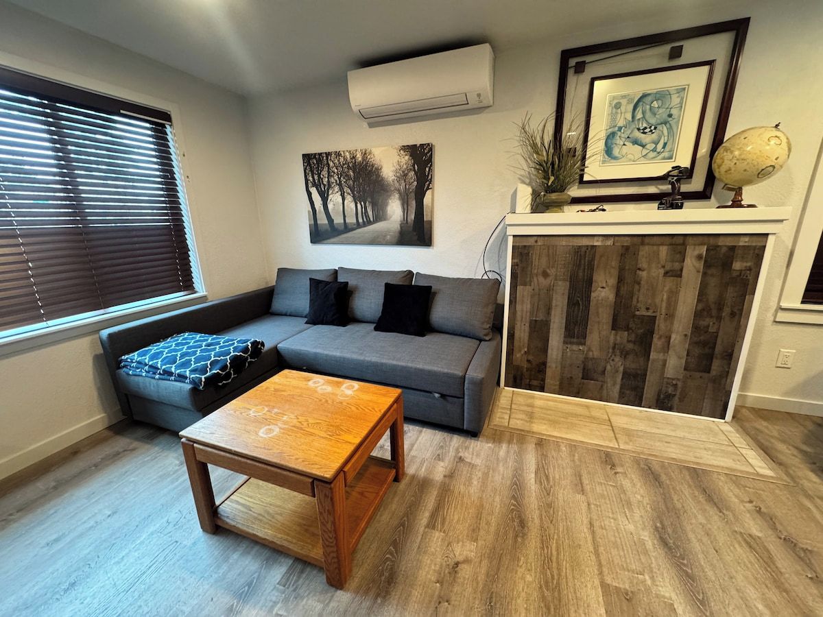 A living room with a sofa, a coffee table, and a fireplace.